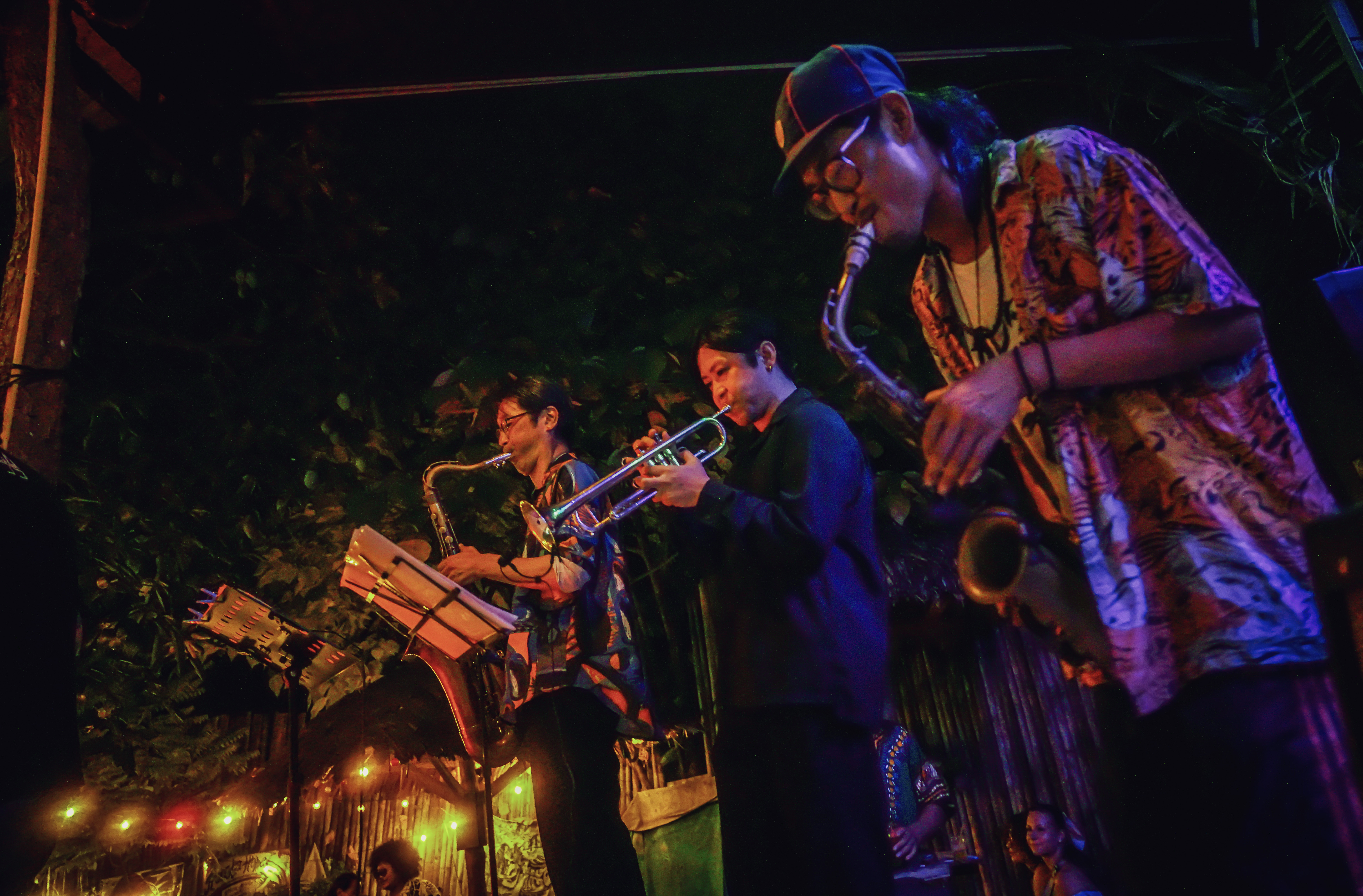 Band with saxophone, trumpet, and percussion performing at Rasta Home.