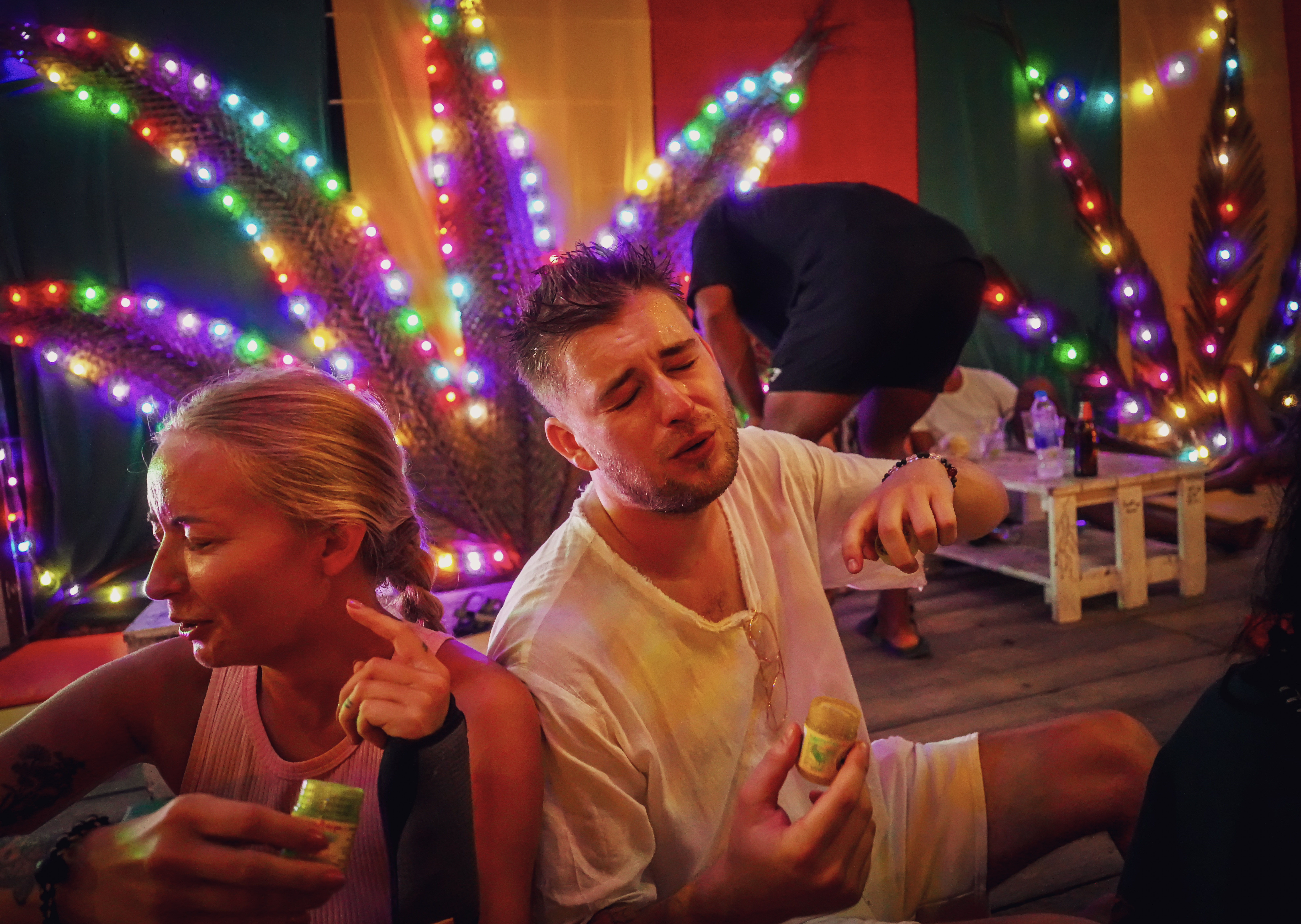 Guest upstairs inhaling Thai herbs with reggae backdrop and colorful lights.
