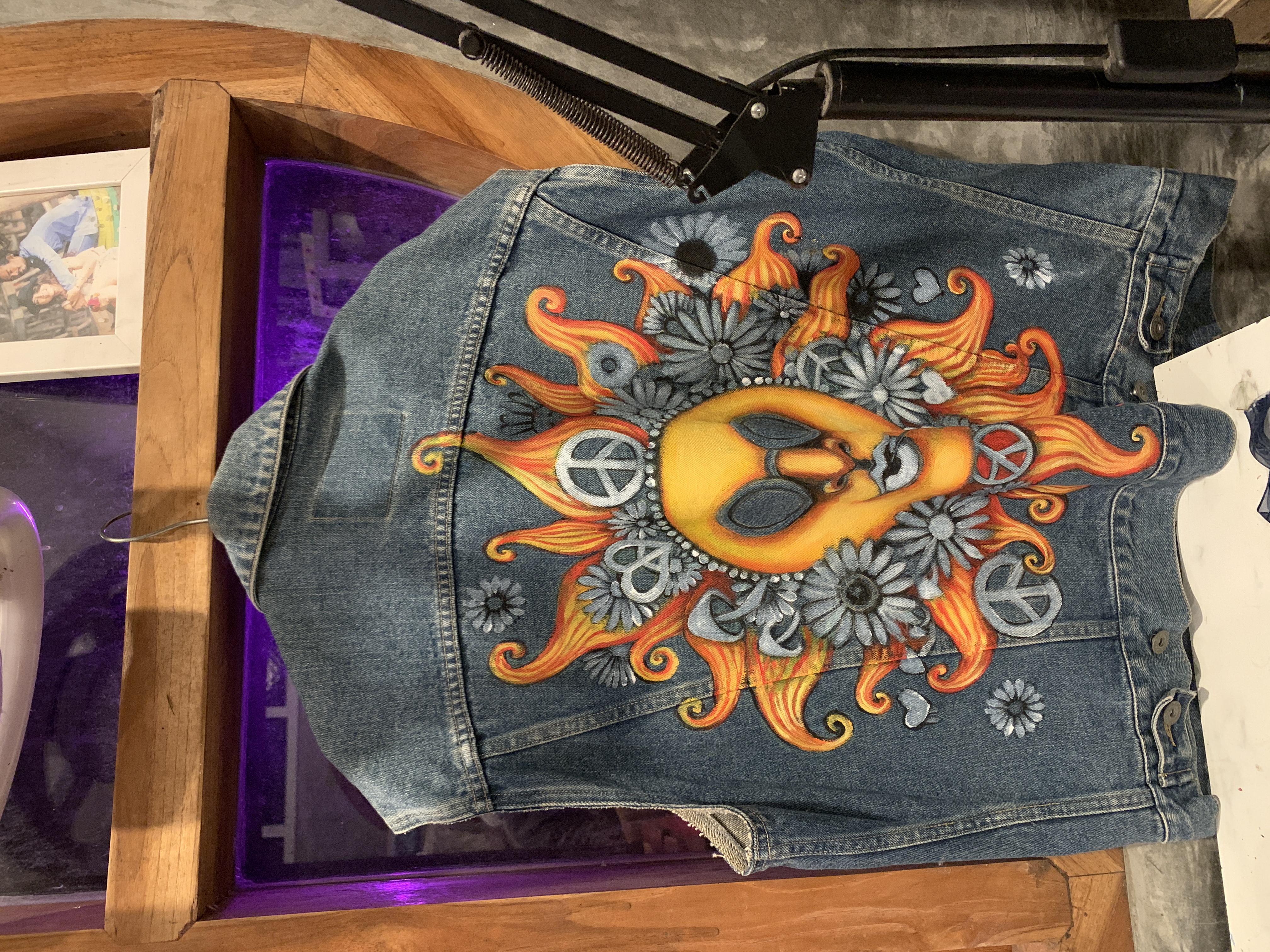 Sleevless denim vest with colorful psychedelic alien artwork.
