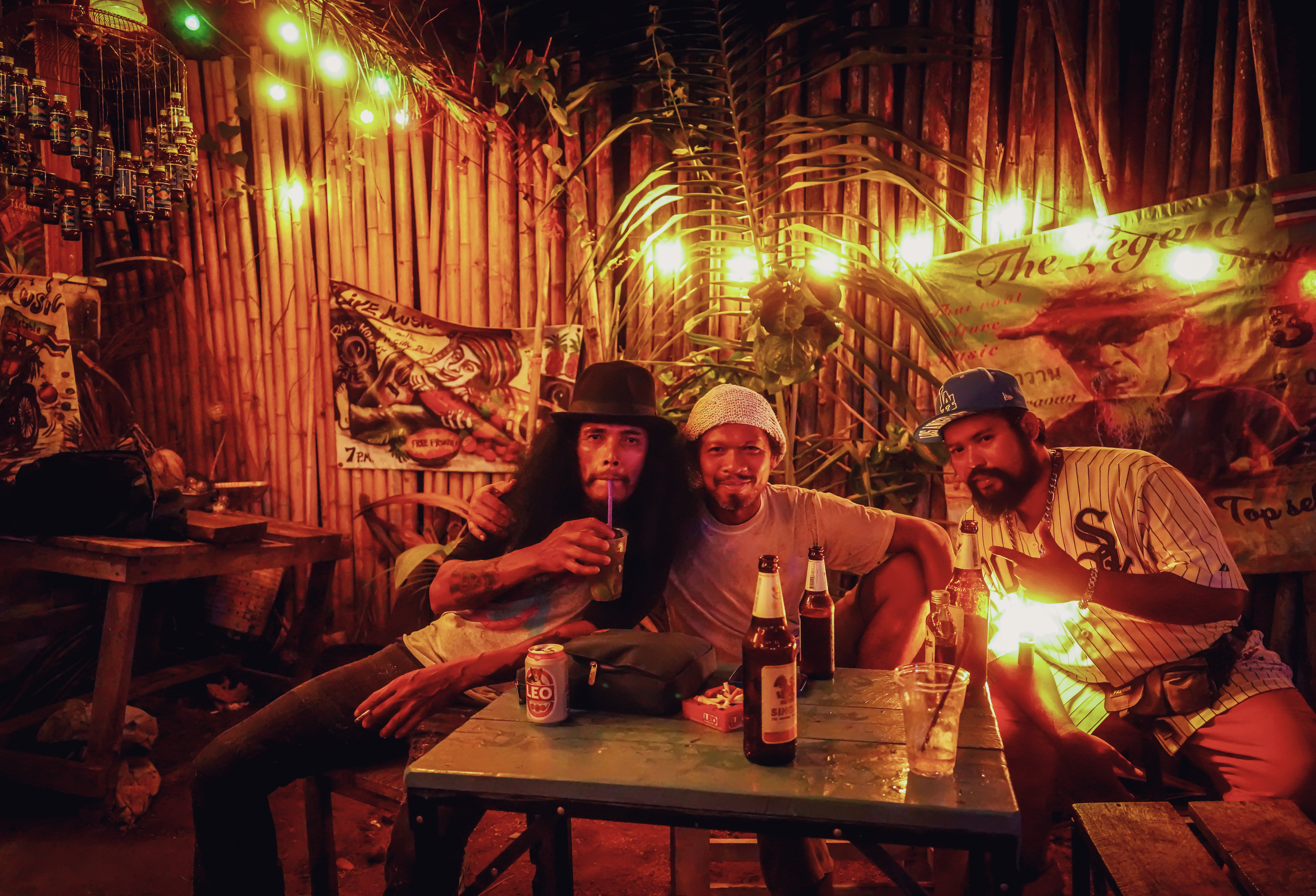 Guest enjoying a beer at Rasta Home Bar with bamboo backdrop